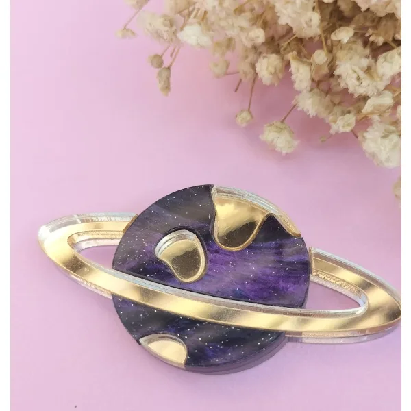 Broche Planeta, metacrilato efecto espejo y marmoleado, estilo moderno y colorido.