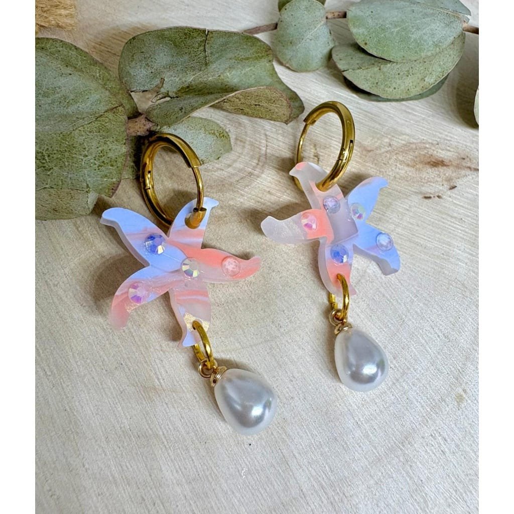 Un pendiente con alma marinera y mucho brillo. 🌊⭐ Estos Pendientes Estrella de Mar Perlada son la mezcla ideal entre elegancia y diversión, perfectos para dar un toque especial a tu look veraniego sin renunciar a la comodidad.