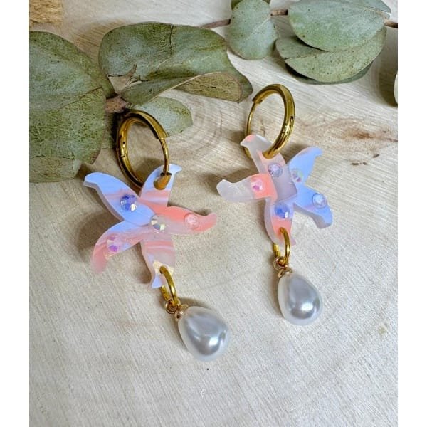 Un pendiente con alma marinera y mucho brillo. 🌊⭐ Estos Pendientes Estrella de Mar Perlada son la mezcla ideal entre elegancia y diversión, perfectos para dar un toque especial a tu look veraniego sin renunciar a la comodidad.