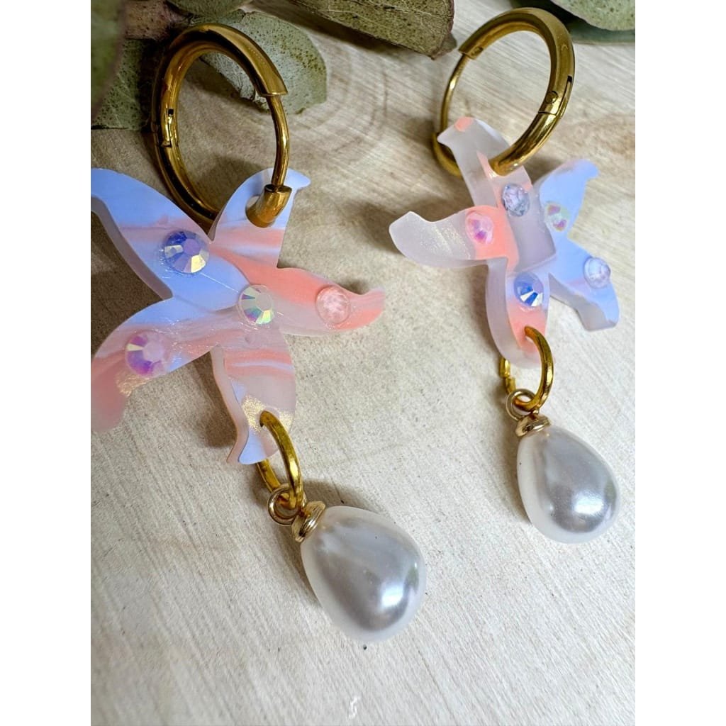 Un pendiente con alma marinera y mucho brillo. 🌊⭐ Estos Pendientes Estrella de Mar Perlada son la mezcla ideal entre elegancia y diversión, perfectos para dar un toque especial a tu look veraniego sin renunciar a la comodidad.