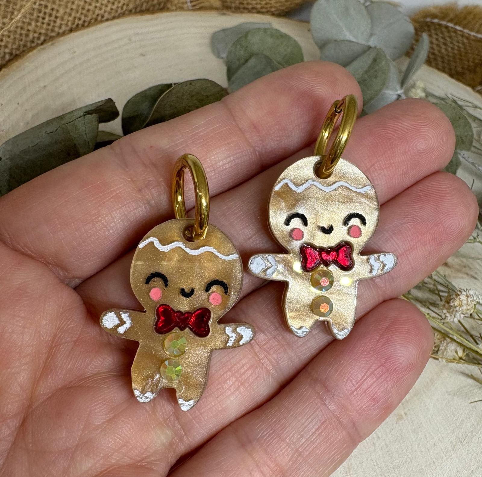 Los Pendientes Galleta de Jengibre llegan a Judithconalma para convertirse en uno de los accesorios más adorables y originales de esta Navidad. Inspirados en el icono más dulce de las fiestas, estos pendientes combinan ternura, brillo y ese toque totalmente artesanal que caracteriza nuestras colecciones navideñas. Fabricados en metacrilato de alta calidad con acabado perlado y detalles pintados a mano, cada galletita tiene un encanto único: mejillas sonrosadas, sonrisa adorable y un lazo rojo efecto espejo que aporta un toque festivo espectacular. Una pieza luminosa y superligera, diseñada para brillar en cenas, quedadas familiares, sesiones de fotos navideñas o cualquier look especial de estas fiestas.