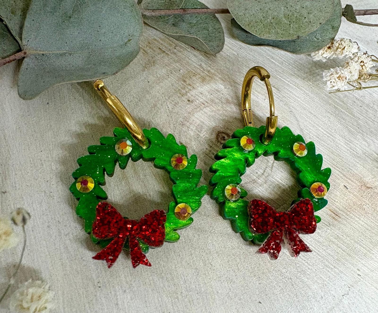 Celebra la magia de estas fiestas con nuestros Pendientes Corona de Navidad, un diseño exclusivo de Judithconalma creado artesanalmente en metacrilato de alta calidad. Su forma de coronita navideña, llena de brillo y detalles, convierte este modelo en el accesorio perfecto para completar tus looks de invierno, cenas familiares, reuniones de empresa o noches especiales.