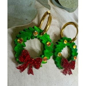 Celebra la magia de estas fiestas con nuestros Pendientes Corona de Navidad, un diseño exclusivo de Judithconalma creado artesanalmente en metacrilato de alta calidad. Su forma de coronita navideña, llena de brillo y detalles, convierte este modelo en el accesorio perfecto para completar tus looks de invierno, cenas familiares, reuniones de empresa o noches especiales.