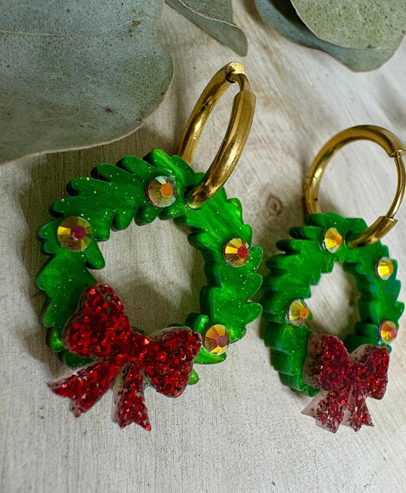 Celebra la magia de estas fiestas con nuestros Pendientes Corona de Navidad, un diseño exclusivo de Judithconalma creado artesanalmente en metacrilato de alta calidad. Su forma de coronita navideña, llena de brillo y detalles, convierte este modelo en el accesorio perfecto para completar tus looks de invierno, cenas familiares, reuniones de empresa o noches especiales.