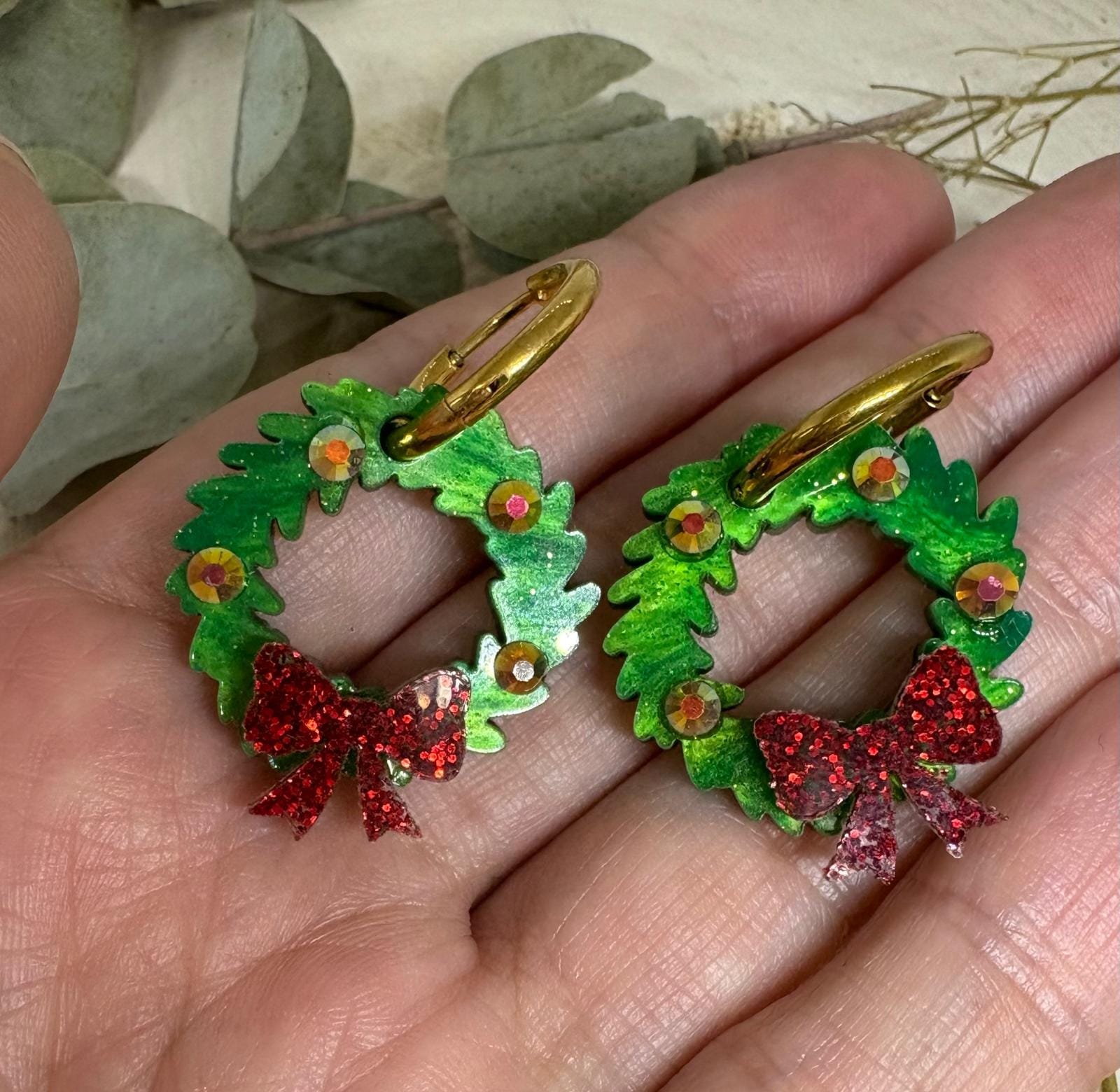 Celebra la magia de estas fiestas con nuestros Pendientes Corona de Navidad, un diseño exclusivo de Judithconalma creado artesanalmente en metacrilato de alta calidad. Su forma de coronita navideña, llena de brillo y detalles, convierte este modelo en el accesorio perfecto para completar tus looks de invierno, cenas familiares, reuniones de empresa o noches especiales.