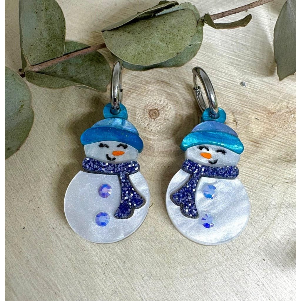 Los Pendientes Muñeco de Nieve llegan para llenar tu Navidad de magia, brillo y ternura. Inspirados en la esencia más bonita del invierno, están diseñados con metacrilatos de importación cuidadosamente seleccionados para lograr un acabado luminoso, resistente y lleno de vida. Cada muñeco de nieve está formado por capas de metacrilato nacarado blanco que aportan un destello suave y elegante, acompañado de detalles en azul glitter que hacen que el diseño destaque desde cualquier ángulo.