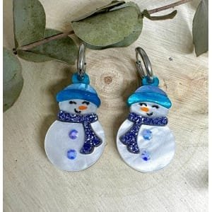 Los Pendientes Muñeco de Nieve llegan para llenar tu Navidad de magia, brillo y ternura. Inspirados en la esencia más bonita del invierno, están diseñados con metacrilatos de importación cuidadosamente seleccionados para lograr un acabado luminoso, resistente y lleno de vida. Cada muñeco de nieve está formado por capas de metacrilato nacarado blanco que aportan un destello suave y elegante, acompañado de detalles en azul glitter que hacen que el diseño destaque desde cualquier ángulo.