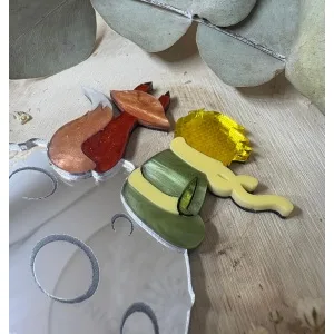 El Broche El Principito es una pieza única que combina artesanía, emoción y diseño. Inspirado en uno de los personajes más entrañables de la literatura universal, este broche está realizado a mano minuciosamente, cuidando cada detalle para crear una joya especial, delicada y llena de significado. Fabricado con metacrilatos de importación de alta calidad, incorpora acabados efecto espejo y marmoleados, que aportan profundidad, brillo y un juego de luces espectacular. Cada capa ha sido cortada con máquina láser de alta precisión, lo que permite un encaje perfecto y una definición impecable en cada forma. Su diseño representa al Principito junto a su inseparable zorro sobre su pequeño planeta, una escena que transmite ternura, amistad y magia. Gracias a la combinación de colores y materiales, el broche resulta llamativo sin perder elegancia, convirtiéndose en un complemento ideal tanto para el día a día como para ocasiones especiales.