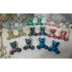Los Pendientes Osito Resina son pura ternura convertida en joya. Un diseño alegre, original y lleno de color que no pasa desapercibido. Cada osito está realizado de forma artesanal con resina epoxi, creando piezas únicas con matices y reflejos irrepetibles. No hay dos iguales, y eso los convierte en un accesorio muy especial.