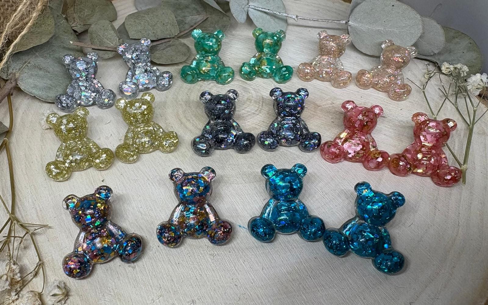 Los Pendientes Osito Resina son pura ternura convertida en joya. Un diseño alegre, original y lleno de color que no pasa desapercibido. Cada osito está realizado de forma artesanal con resina epoxi, creando piezas únicas con matices y reflejos irrepetibles. No hay dos iguales, y eso los convierte en un accesorio muy especial.