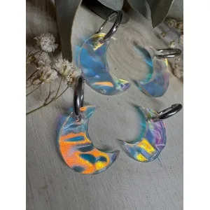 Un diseño que atrapa la luz y no pasa desapercibido. Las Lunas iridiscentes texturizadas son un modelo exclusivo de Judithconalma, creado para quienes buscan pendientes diferentes, ligeros y con un brillo especial que cambia según la luz y el movimiento. Cada luna está realizada en metacrilato iridiscente de última generación, con una textura sutil que aporta profundidad y reflejos únicos en tonos nacarados, azules, rosados y dorados. No hay dos iguales: cada pieza tiene su propio juego de luces. Diseño exclusivo y hecho a mano