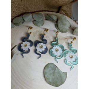 Un diseño con carácter, simbolismo y elegancia. Los Pendientes Serpiente Metacrilato son un modelo exclusivo de Judithconalma que une fuerza y delicadeza en una misma pieza. La serpiente, símbolo de transformación y poder, se combina con una flor marmoleada luminosa que aporta equilibrio, luz y feminidad. Un contraste que convierte este diseño en algo verdaderamente especial.