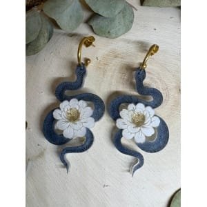 Un diseño con carácter, simbolismo y elegancia. Los Pendientes Serpiente Metacrilato son un modelo exclusivo de Judithconalma que une fuerza y delicadeza en una misma pieza. La serpiente, símbolo de transformación y poder, se combina con una flor marmoleada luminosa que aporta equilibrio, luz y feminidad. Un contraste que convierte este diseño en algo verdaderamente especial.
