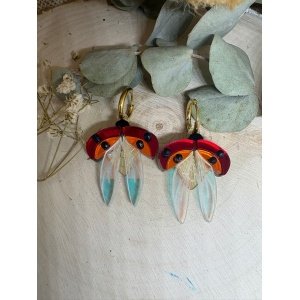 Pendientes de metacrilato artesanales – Diseño exclusivo JudithconAlma Los Pendientes Mariquitas en Vuelo son una pieza alegre, delicada y llena de simbolismo. Inspirados en la naturaleza y en uno de los insectos más queridos, estos pendientes capturan la imagen de dos mariquitas desplegando sus alas en pleno vuelo. Las mariquitas son símbolo de buena suerte, alegría y prosperidad, lo que convierte a estos pendientes en un complemento especial tanto para el día a día como para ocasiones especiales. Cada pieza está elaborada con metacrilatos de importación de alta calidad, seleccionados por su brillo, resistencia y ligereza. La combinación de colores y transparencias recrea el movimiento de las alas abiertas, aportando luz y un efecto visual muy atractivo.