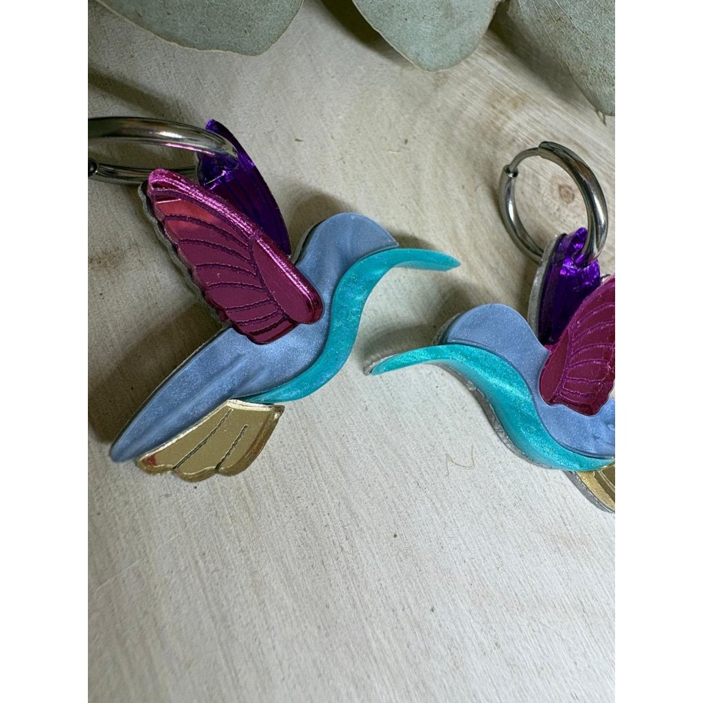 Los Pendientes Colibrí son una auténtica joya llena de color, movimiento y originalidad. Un diseño exclusivo que no pasa desapercibido, elaborado con metacrilatos de alta calidad para conseguir un acabado único, ligero y muy favorecedor. Características: Metacrilatos de importación de alta calidad Corte láser de precisión Diseño exclusivo Colibrí Medidas: 3,4 x 2,8 cm (sin aro) Aro de 1,5 cm Disponible en versión multicolor o tonos verdes Combinación de acabados espejo, marmoleado y translúcido Ligeros, cómodos y muy vistosos