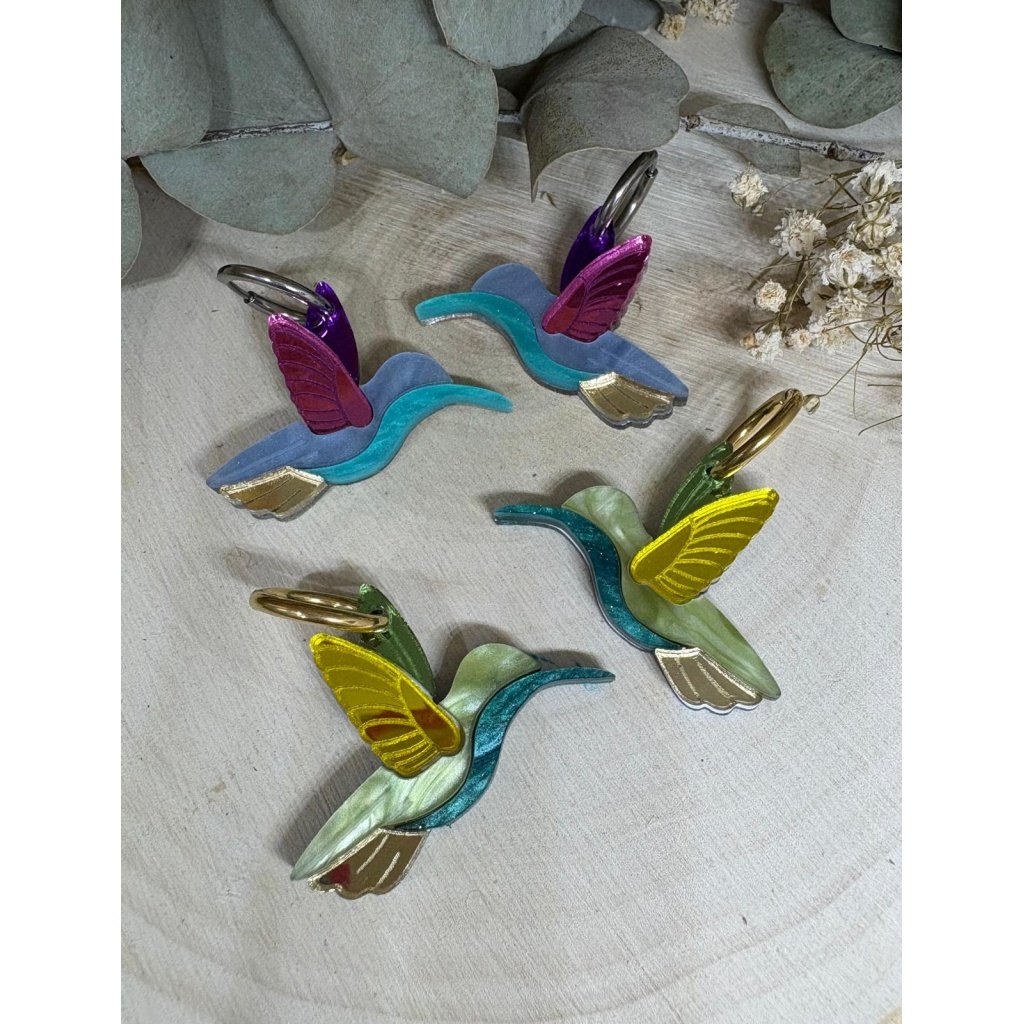 Los Pendientes Colibrí son una auténtica joya llena de color, movimiento y originalidad. Un diseño exclusivo que no pasa desapercibido, elaborado con metacrilatos de alta calidad para conseguir un acabado único, ligero y muy favorecedor. Características: Metacrilatos de importación de alta calidad Corte láser de precisión Diseño exclusivo Colibrí Medidas: 3,4 x 2,8 cm (sin aro) Aro de 1,5 cm Disponible en versión multicolor o tonos verdes Combinación de acabados espejo, marmoleado y translúcido Ligeros, cómodos y muy vistosos