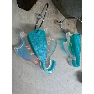 Pendientes Manta Raya – Colección Verano 2026 Los Pendientes Manta Raya de Judith con Alma son una pieza original y elegante inspirada en la belleza y la libertad del océano. Su diseño exclusivo reproduce la silueta de una manta raya en movimiento, creando unos pendientes únicos que evocan el mar, el verano y los días de playa. Fabricados artesanalmente con metacrilatos de importación de alta calidad, combinan un espectacular tono turquesa marmoleado con un metacrilato iridiscente que refleja diferentes colores según la luz. El resultado es una joya ligera, llamativa y llena de personalidad que no pasa desapercibida. Cada pendiente está cortado con tecnología láser de alta precisión, consiguiendo acabados limpios y detalles perfectamente definidos. Su tamaño de 3 x 3 cm (sin aro) los convierte en un complemento cómodo y versátil para el día a día, mientras que el aro fino plateado de 2 cm aporta un toque moderno y elegante. Estos pendientes forman parte de la exclusiva Colección Verano 2026 de Judith con Alma, una colección inspirada en el mar, la costa y la naturaleza marina. Son ideales para completar un look veraniego, para tus vacaciones, una cena junto al mar o simplemente para aportar frescura y originalidad a cualquier conjunto. Si buscas pendientes originales de metacrilato, pendientes inspirados en el mar o complementos artesanales diferentes, los Pendientes Manta Raya son la elección perfecta. Características principales Diseño exclusivo Judith con Alma. Inspirados en las mantas raya y el mundo marino. Fabricados con metacrilatos de importación de alta calidad. Combinación de metacrilato turquesa y efecto iridiscente. Corte láser de alta precisión. Muy ligeros y cómodos de llevar. Medida de la figura: 3 x 3 cm. Aro fino plateado de 2 cm. Ideales para looks de verano. Pieza artesanal realizada en pequeñas series. Colección Verano 2026.