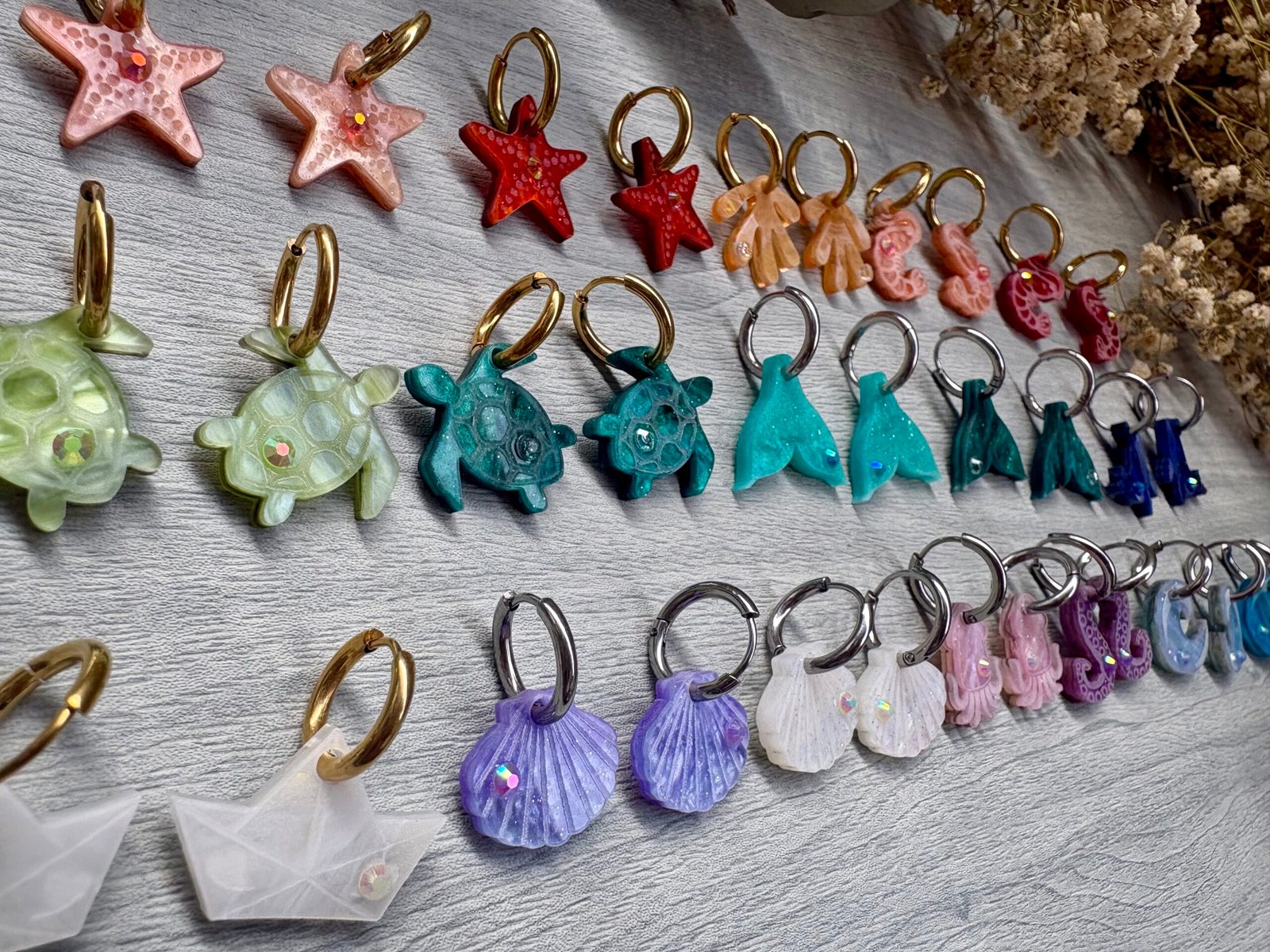 Descubre TESOROS DEL MAR, la colección más divertida y personalizable del verano. Pendientes inspirados en el océano para crear combinaciones únicas, llenas de color, brillo y personalidad. Elige tus figuras favoritas, mezcla colores y crea un diseño totalmente a tu gusto. Características: Diseño exclusivo de JudithconAlma Modelos disponibles: concha, coral, estrella de mar, ballena, tortuga, ola, cola de ballena, barco de papel, tentáculos, sepia y gambitas Tamaño aproximado: 1,7 x 1,7 cm Posibilidad de elegir pendientes iguales o diferentes Personalizables en color y combinación Opción con aro o sin aro Aro disponible en color dorado o plateado Aros de acero inoxidable aptos para alergias Ligeros y muy cómodos de llevar Perfectos para looks veraniegos, coloridos y desenfadados Ideales para playa, vacaciones, festivales y verano Cada combinación es única y hecha con mucho mimo