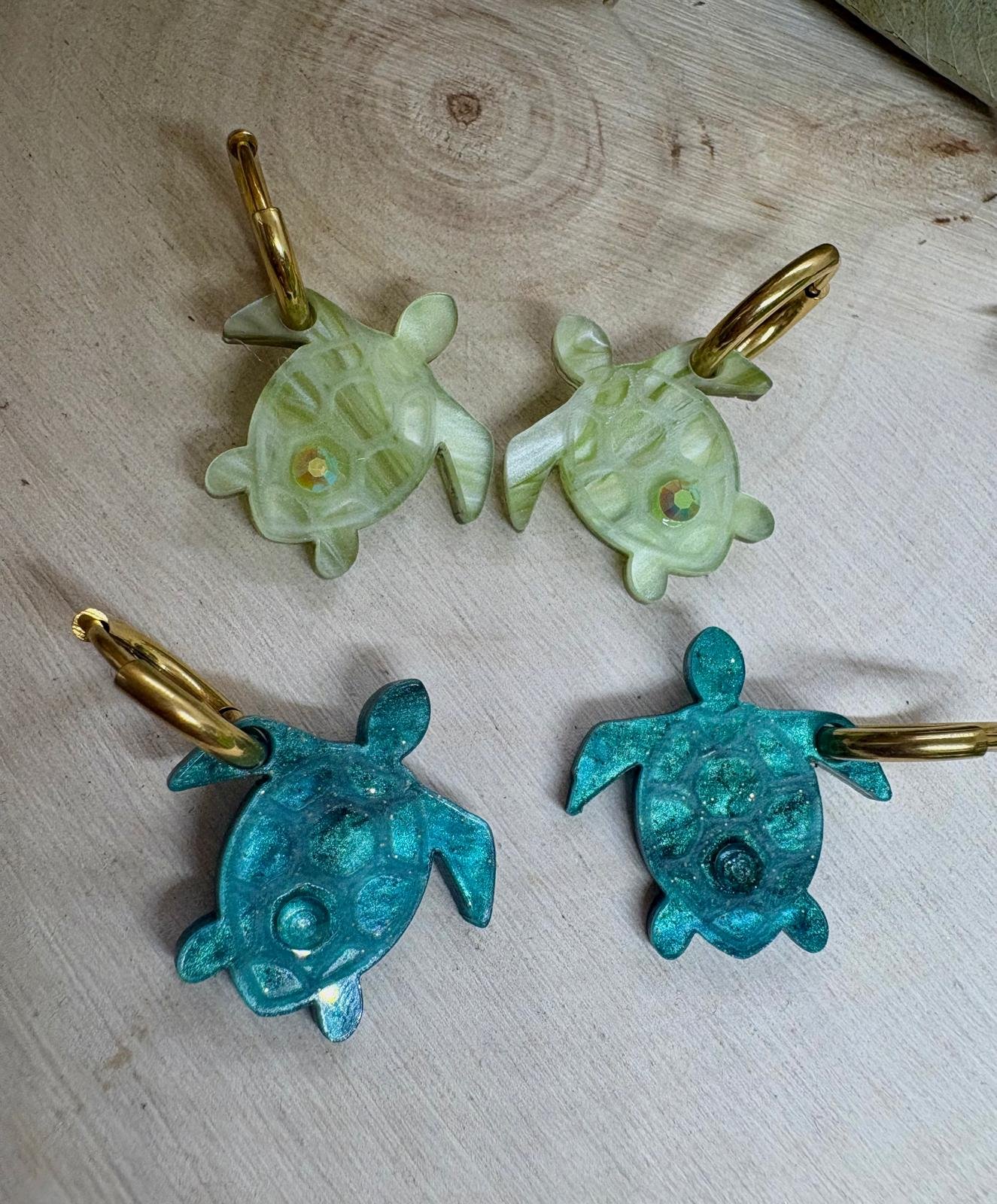 Descubre TESOROS DEL MAR, la colección más divertida y personalizable del verano. Pendientes inspirados en el océano para crear combinaciones únicas, llenas de color, brillo y personalidad. Elige tus figuras favoritas, mezcla colores y crea un diseño totalmente a tu gusto. Características: Diseño exclusivo de JudithconAlma Modelos disponibles: concha, coral, estrella de mar, ballena, tortuga, ola, cola de ballena, barco de papel, tentáculos, sepia y gambitas Tamaño aproximado: 1,7 x 1,7 cm Posibilidad de elegir pendientes iguales o diferentes Personalizables en color y combinación Opción con aro o sin aro Aro disponible en color dorado o plateado Aros de acero inoxidable aptos para alergias Ligeros y muy cómodos de llevar Perfectos para looks veraniegos, coloridos y desenfadados Ideales para playa, vacaciones, festivales y verano Cada combinación es única y hecha con mucho mimo