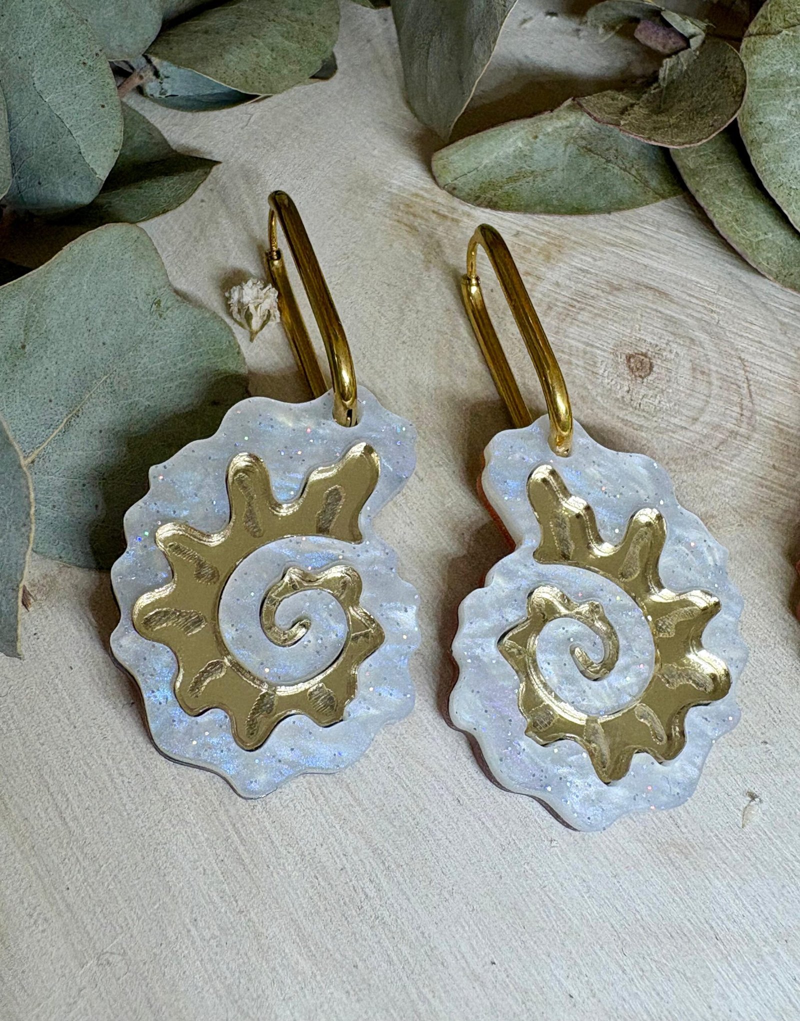 Pendientes Caracola de Metacrilato – Diseño Elegante y Original Los Pendientes Caracola son una auténtica joyita inspirada en el mar y en las formas orgánicas de la naturaleza. Un diseño original y sofisticado que combina diferentes metacrilatos para crear un efecto visual espectacular, lleno de brillo, textura y personalidad. Su forma de caracola aporta un estilo elegante pero diferente, perfecto para quienes buscan unos pendientes de metacrilato originales, ligeros y con mucho encanto. La mezcla de acabados nacarados, efecto brillo y espejo dorado convierte cada pieza en un complemento único y muy favorecedor. Además, puedes elegir entre dos tipos de aro para adaptarlos totalmente a tu estilo: aro ovalado o aro redondo. ✨ Características principales 🐚 Diseño exclusivo inspirado en caracolas marinas 🎨 Combinación de varios metacrilatos de alta calidad ✂️ Corte láser de precisión 💎 Acabados nacarados, brillo y efecto espejo 📏 Medidas: 3,5 x 2,4 cm (sin aro) 🔘 Opciones de aro: Ovalado: 2 cm x 1,5 cm Redondo: 1,8 cm 🪶 Muy ligeros y cómodos ✋ Hechos a mano con muchísimo mimo 🌊 Diseño elegante, original y muy veraniego Perfectos para elevar cualquier look y aportar un toque especial tanto en el día a día como en ocasiones especiales. Si te encantan los complementos diferentes y con personalidad, estos pendientes están hechos para ti.