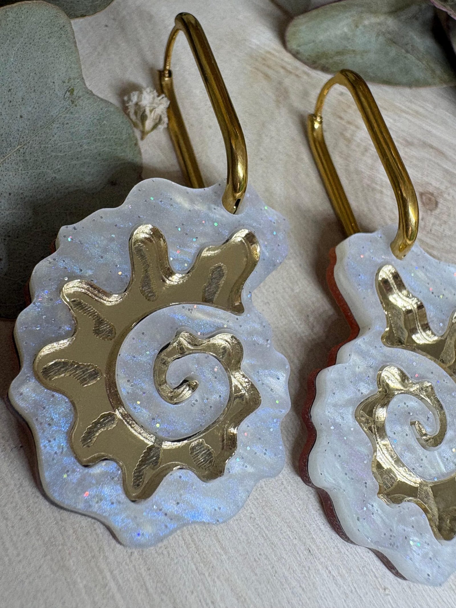 Pendientes Caracola de Metacrilato – Diseño Elegante y Original Los Pendientes Caracola son una auténtica joyita inspirada en el mar y en las formas orgánicas de la naturaleza. Un diseño original y sofisticado que combina diferentes metacrilatos para crear un efecto visual espectacular, lleno de brillo, textura y personalidad. Su forma de caracola aporta un estilo elegante pero diferente, perfecto para quienes buscan unos pendientes de metacrilato originales, ligeros y con mucho encanto. La mezcla de acabados nacarados, efecto brillo y espejo dorado convierte cada pieza en un complemento único y muy favorecedor. Además, puedes elegir entre dos tipos de aro para adaptarlos totalmente a tu estilo: aro ovalado o aro redondo. ✨ Características principales 🐚 Diseño exclusivo inspirado en caracolas marinas 🎨 Combinación de varios metacrilatos de alta calidad ✂️ Corte láser de precisión 💎 Acabados nacarados, brillo y efecto espejo 📏 Medidas: 3,5 x 2,4 cm (sin aro) 🔘 Opciones de aro: Ovalado: 2 cm x 1,5 cm Redondo: 1,8 cm 🪶 Muy ligeros y cómodos ✋ Hechos a mano con muchísimo mimo 🌊 Diseño elegante, original y muy veraniego Perfectos para elevar cualquier look y aportar un toque especial tanto en el día a día como en ocasiones especiales. Si te encantan los complementos diferentes y con personalidad, estos pendientes están hechos para ti.
