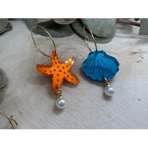 Pendientes Concha y Estrella – El toque más veraniego y original para tus looks 🌊⭐ Los nuevos Pendientes Concha y Estrella llegan para convertirse en uno de esos accesorios que no pasan desapercibidos. Inspirados en el mar, el verano y la luz de la playa, estos pendientes combinan diseños originales con metacrilatos de importación llenos de brillo, color y personalidad. Su combinación de tonos azules intensos, estrellas de mar naranjas y pequeñas perlas decorativas crea un efecto fresco, elegante y muy divertido, ideal para quienes buscan unos pendientes originales hechos a mano con un estilo diferente. Además, puedes elegir la combinación que más te guste: ✨ Dos conchas ✨ Dos estrellas ✨ Una concha y una estrella Cada pieza está elaborada con materiales de alta calidad y cortada mediante máquina láser de alta precisión, logrando acabados cuidados y llenos de detalle. Un diseño perfecto para verano 🌴 Estos pendientes tienen un aire mediterráneo y veraniego que combina genial con vestidos, looks ibicencos, ropa blanca, outfits coloridos o incluso estilos más básicos a los que quieras dar un toque especial. Las pequeñas perlas colgantes aportan elegancia y movimiento, mientras que los metacrilatos translúcidos hacen que brillen muchísimo con la luz. Son ideales para: Vacaciones y viajes Eventos de verano Cenas junto al mar Festivales Regalos originales Amantes de los accesorios artesanales Características de los Pendientes Concha y Estrella Medidas del pendiente: 3,2 x 2 cm (sin aro) Medida del aro fino: 2 cm Posibilidad de elegir: Dos estrellas Dos conchas Una estrella y una concha Metacrilatos de importación de alta calidad Fabricados con máquina láser de alta precisión Pendientes ligeros y cómodos Diseño original y artesanal Look veraniego y fresco Acabados brillantes y llenos de color Pendientes originales hechos a mano En Judith Con Alma apostamos por crear accesorios diferentes, llenos de personalidad y fabricados con muchísimo cariño. Estos pendientes son perfectos para quienes aman el mar, el verano y los complementos únicos. Si buscas unos pendientes veraniegos originales, con estilo artesanal y materiales de calidad, los Pendientes Concha y Estrella son una opción preciosa para completar cualquier look.