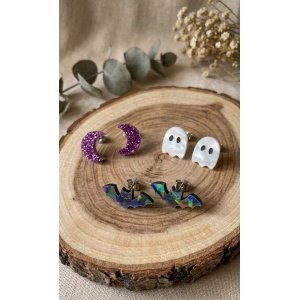 Pack Pendientes Halloween Minis – Colección Halloween 2026 ¡El set definitivo para combinar tus *looks* más mágicos y divertidos este otoño! Presentamos el **Pack Pendientes Halloween Minis** de **Judith con Alma**, un conjunto exclusivo de nuestra **Colección Halloween 2026** compuesto por tres pares de pendientes de botón (*studs*) pequeños, cómodos y llenos de encanto. Diseñados especialmente para quienes aman los detalles discretos pero deslumbrantes o para combinar varios pendientes en la misma oreja (*ear candy*), este trió temático te permitirá lucir un estilo diferente cada día o mezclar las figuras a tu gusto. ¿Qué incluye el pack? El set incluye **3 pares de pendientes independientes** con acabados y materiales premium de alta calidad: 1. **Lunas Moradas Glitter:** Encantadoras medias lunas elaboradas en metacrilato morado rugoso con purpurina de gran brillo, ideales para un toque místico y sideral. 2. **Fantasmitas Nácar/Nube:** Lindos fantasmas en metacrilato blanco con reflejos nacarados/iridiscentes y ojitos calados, perfectos para dar un aire tierno y *cute*. 3. **Murciélagos Holo/Iridiscentes:** Simpáticos murciélagos en metacrilato oscuro con un fascinante acabado holográfico que refleja destellos multicolor según la luz. --- ### ✨ Características y Calidad Excepcional * **Diseño 100% Exclusivo:** Creación original de Judith con Alma, ideada para ofrecerte versatilidad y diversión en un solo producto. * **Metacrilatos de Importación Seleccionados:** Una combinación exquisita de metacrilato glitter, efecto nacarado/perlado e holográfico sobre corte láser de alta precisión. * **Cómodos y Ligero:** Al ser de tamaño mini y formato botón, apenas notarás que los llevas puestos, siendo ideales para uso diario o para segundos y terceros agujeros. * **Fornturas Hipoalergénicas:** Montados sobre tuercas y pernos de **acero inoxidable**, garantizando máxima durabilidad y cuidado incluso en las pieles más sensibles. --- ### 📏 Especificaciones Técnicas * **Tamaño de las piezas:** Entre 1,5 cm y 2 cm aprox. (dependiendo del modelo). * **Tipo de cierre:** Perro con tuerca de mariposa en **acero inoxidable** antialérgico. * **Contenido:** 3 pares completos (6 pendientes en total: 2 lunas, 2 fantasmas, 2 murciélagos). * **Colección:** Halloween 2026 – Judith con Alma.