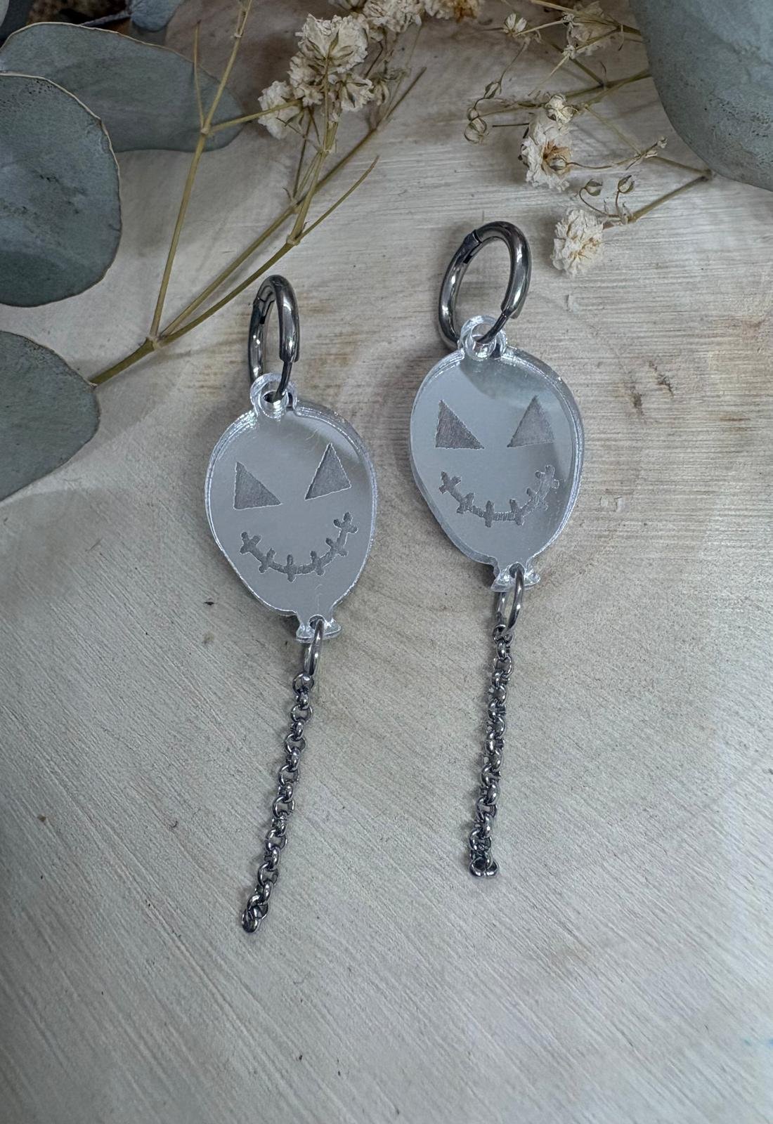 Dale un toque terroríficamente original a tus looks con los Pendientes Globos con Cadena de Judithconalma. Su diseño de globos con caritas de Halloween y cadena colgante aporta movimiento, personalidad y un estilo único. ¡El complemento perfecto para lucir diferente durante la temporada más spooky del año! Características: - Colección: Halloween 2026. - Medidas: 5 x 1,7 cm aproximadamente. - Material: Metacrilato de primera calidad. - Diseño: Globos con cara terrorífica y cadena colgante metálica. - Corte: Láser de alta precisión. - Estilo: Original, divertido y atrevido. - Marca: Diseño exclusivo de Judithconalma.