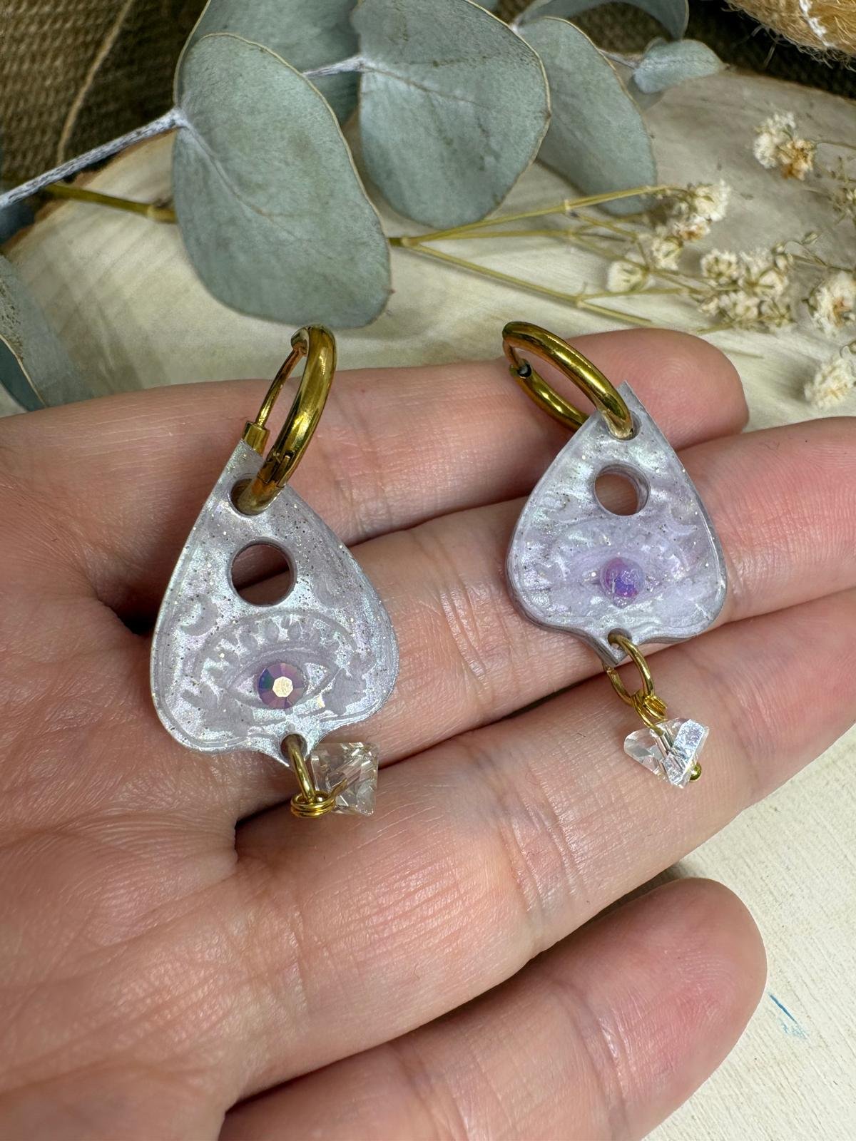 Pendientes Puntero Ouija | Colección Halloween 2026 Atrévete a completar tus looks más misteriosos con los Pendientes Puntero Ouija de Judithconalma, un diseño original inspirado en el universo esotérico, las sesiones de espiritismo y la estética mágica de Halloween. 🖤 Estos pendientes destacan por su forma de puntero de ouija, con un precioso acabado en tonos lila, detalles brillantes y un delicado adorno colgante que aporta movimiento y luminosidad. Los aros dorados crean un contraste elegante con el metacrilato, dando lugar a una combinación muy especial entre lo misterioso, lo original y lo sofisticado. Su diseño es perfecto para quienes buscan pendientes originales de Halloween que se salgan de lo habitual. Ideales para fiestas temáticas, looks alternativos o para añadir un toque mágico y diferente a tus conjuntos durante el otoño. Como parte de la colección exclusiva de Halloween 2026 de Judithconalma, estos pendientes están pensados para las amantes de los accesorios únicos, la bisutería creativa y los complementos con personalidad. Su tamaño permite lucir un diseño llamativo sin renunciar a la versatilidad, convirtiéndolos en una opción estupenda tanto para ocasiones especiales como para dar un toque diferente a tus estilismos cotidianos. Combínalos con prendas negras, tonos morados o accesorios de inspiración gótica para conseguir un look de Halloween espectacular. También son una idea de regalo original para quienes disfrutan de la estética mística, las ouijas y los complementos diferentes. Características de los Pendientes Puntero Ouija - Nombre: Pendientes Puntero Ouija. - Marca: Judithconalma. - Colección: Halloween 2026. - Diseño: Puntero inspirado en las tablas ouija, con detalles decorativos y abalorio colgante. - Material: Metacrilato de primera calidad. - Medidas aproximadas: 3 x 1,5 cm. - Aros: Acabado dorado. - Estilo: Esotérico, misterioso, original y alternativo. - Fabricación: Corte con máquina láser de alta precisión. - Ideal para: Halloween, fiestas temáticas y looks con personalidad. ¿Preparada para invocar tu lado más original? Los Pendientes Puntero Ouija son ese complemento especial que dará a tus looks un toque misterioso, brillante y muy Judithconalma. ✨ Acumbamail Acumbamail: email marketing, SMS y landing pages Herramienta de marketing en castellano